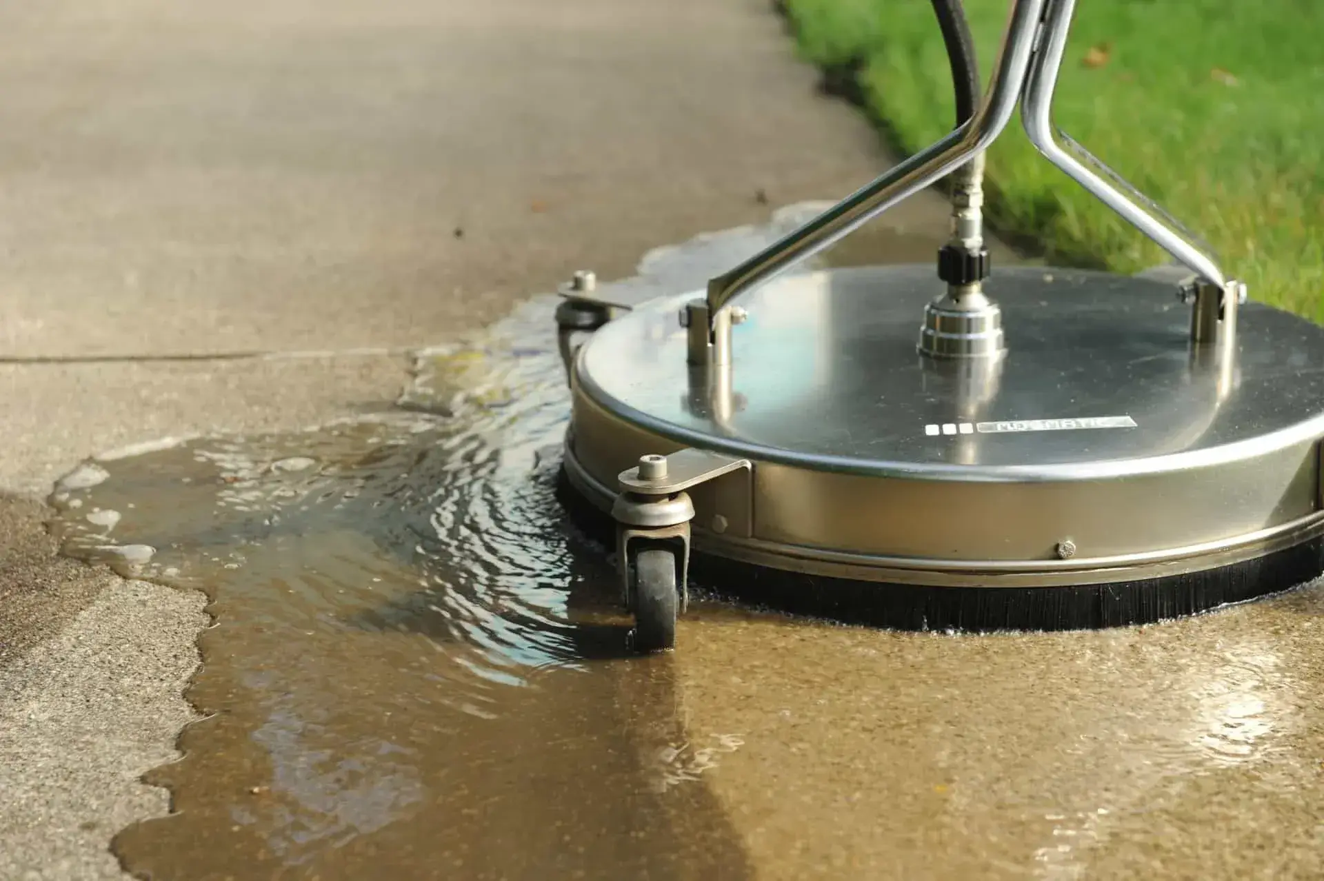 High-pressure washing removing moss from block paving