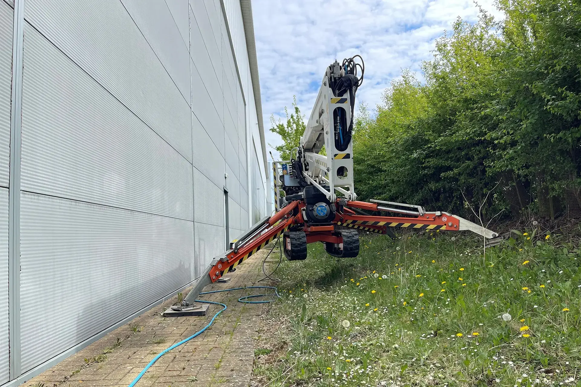 Spider cherry picker navigating tight access on tracked chassis